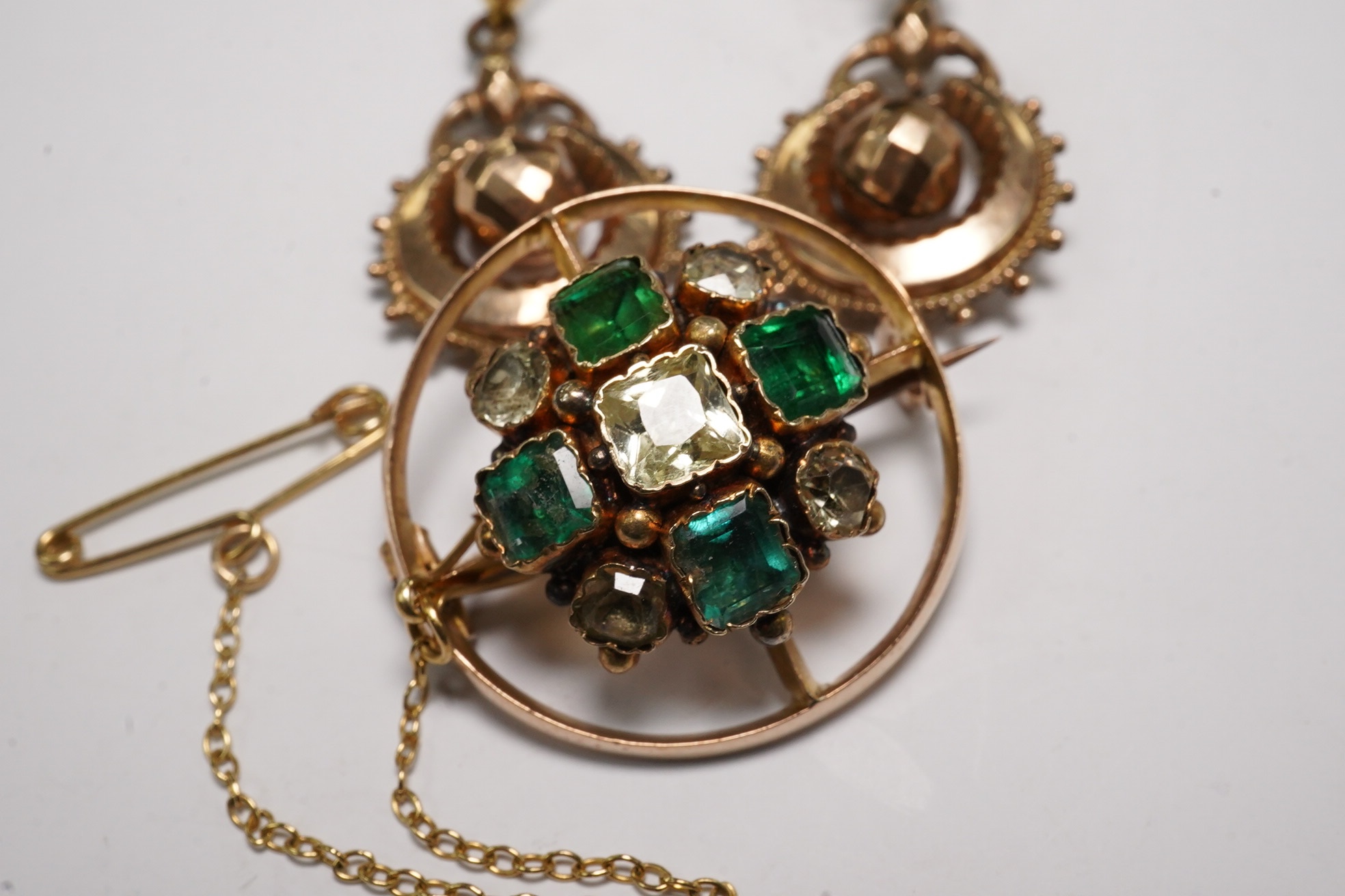A pair of antique yellow metal drop earrings, 22mm and a yellow metal and two colour green gem set brooch. Condition - poor to fair